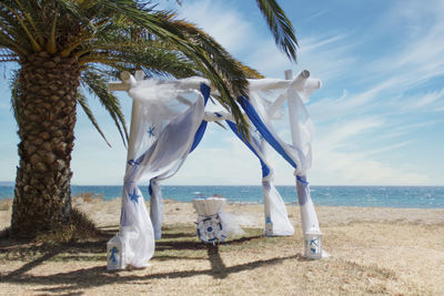 View of white wedding installation on beach against sky