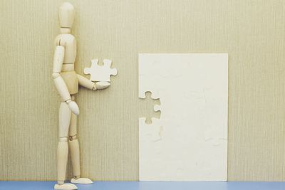 Close-up of figurine with paper on table