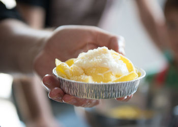 Close-up of hand holding crepes and cream