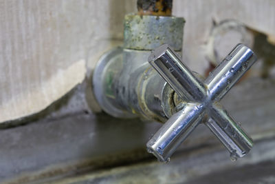 Close-up of old faucet on wall