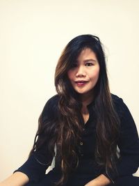 Portrait of smiling woman against white background