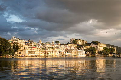 River by houses in town against sky