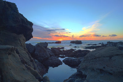 View of rocky beach at sunset