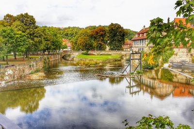 Scenic view of lake by buildings against sky