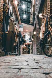 Bicycles parked on footpath at illuminated market in city