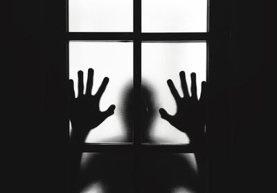Shadow of person hand on glass window