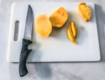 High angle view of fruits and knife on cutting board