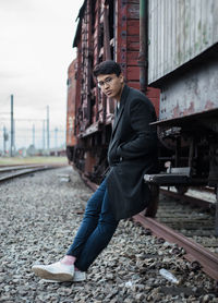 Portrait of young man leaning on train