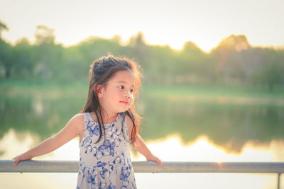 Portrait of girl standing against lake