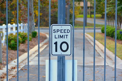 Close-up of road sign on metallic gate