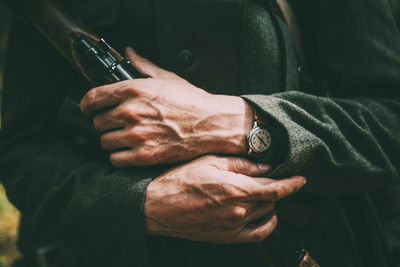 Midsection of man holding smart phone