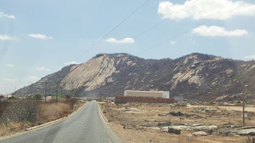 Road by mountain against sky