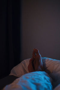 Low section of woman relaxing on bed at home