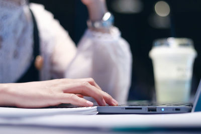 Midsection of person using mobile phone on table