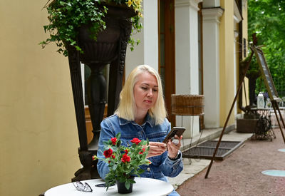 Portrait of smiling young woman sitting on table