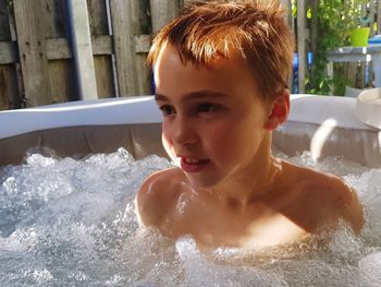 Shirtless boy in hot tub