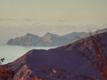 Scenic view of sea and mountains against sky