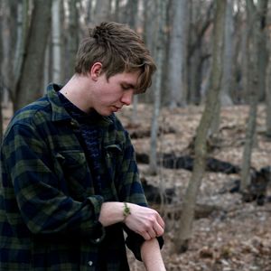 Young man looking away in forest