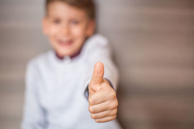 Portrait of smiling boy showing thumbs up