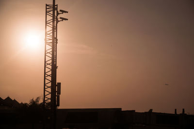 Low angle view of silhouette crane against sky during sunset