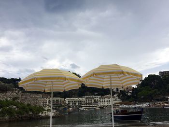 View of boats in sea against cloudy sky