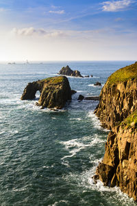 View of rocks at calm sea against the sky