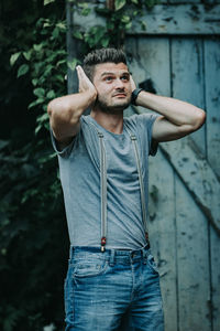 Portrait of young man standing against wall