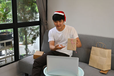 Young woman using mobile phone while sitting on table