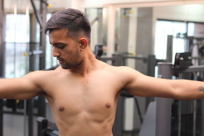 Shirtless man exercising in gym