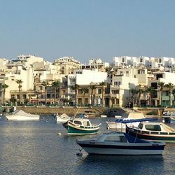 Boats in river with buildings in background