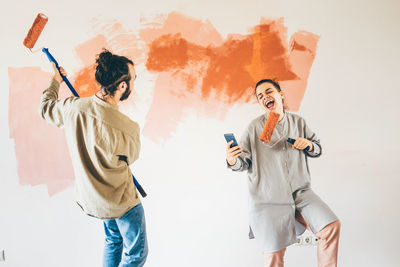 Full length of female friends standing against white background