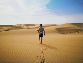 Full length rear view of man on desert