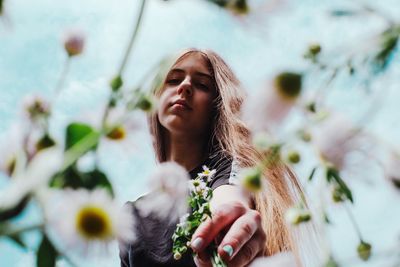 Low angle view of woman on flowering plant