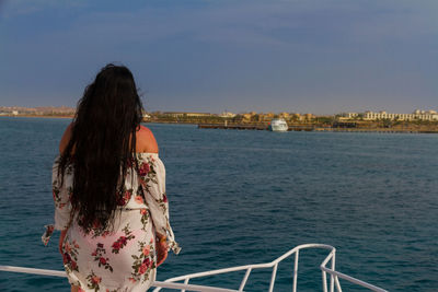 Rear view of woman looking at sea against sky