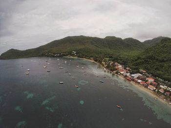 High angle view of people on sea by mountain against sky