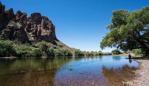 Scenic view of lake against clear blue sky