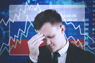 Close-up of tensed businessman against charts