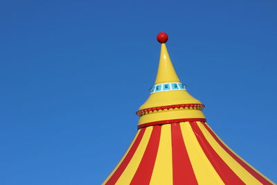 Low angle view of multi colored building against clear blue sky