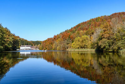 Scenic view of lake against clear blue sky during autumn