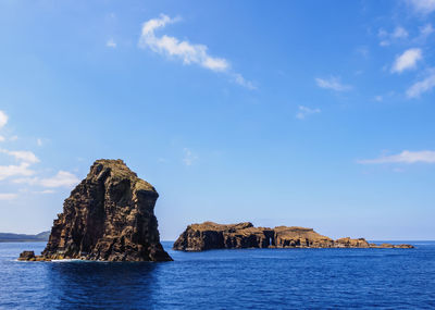 Rock formations in sea against sky