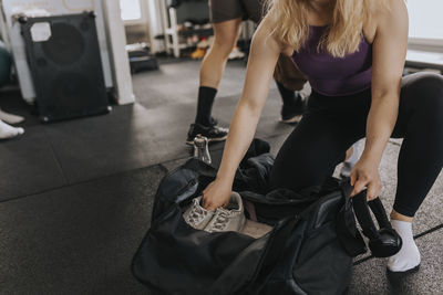 Woman packing equipment after workout in gym