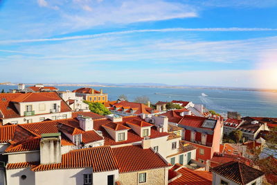 High angle view of townscape by sea against sky