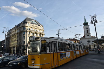 Cars on street in city against sky