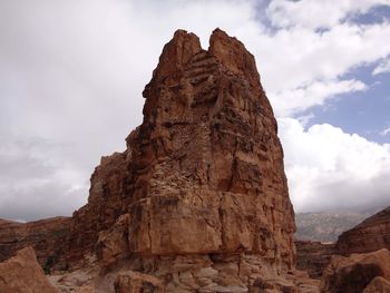 Low angle view of rock formation against cloudy sky