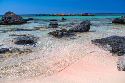 Surface level of rocks on beach against sky