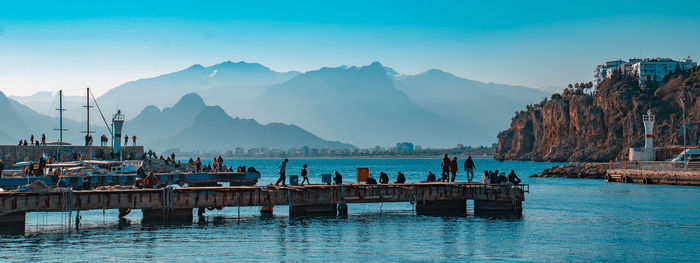 View of boats in sea against mountain range