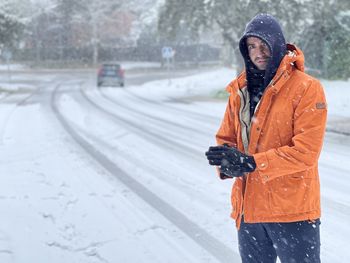 Man standing on snow covered road during winter