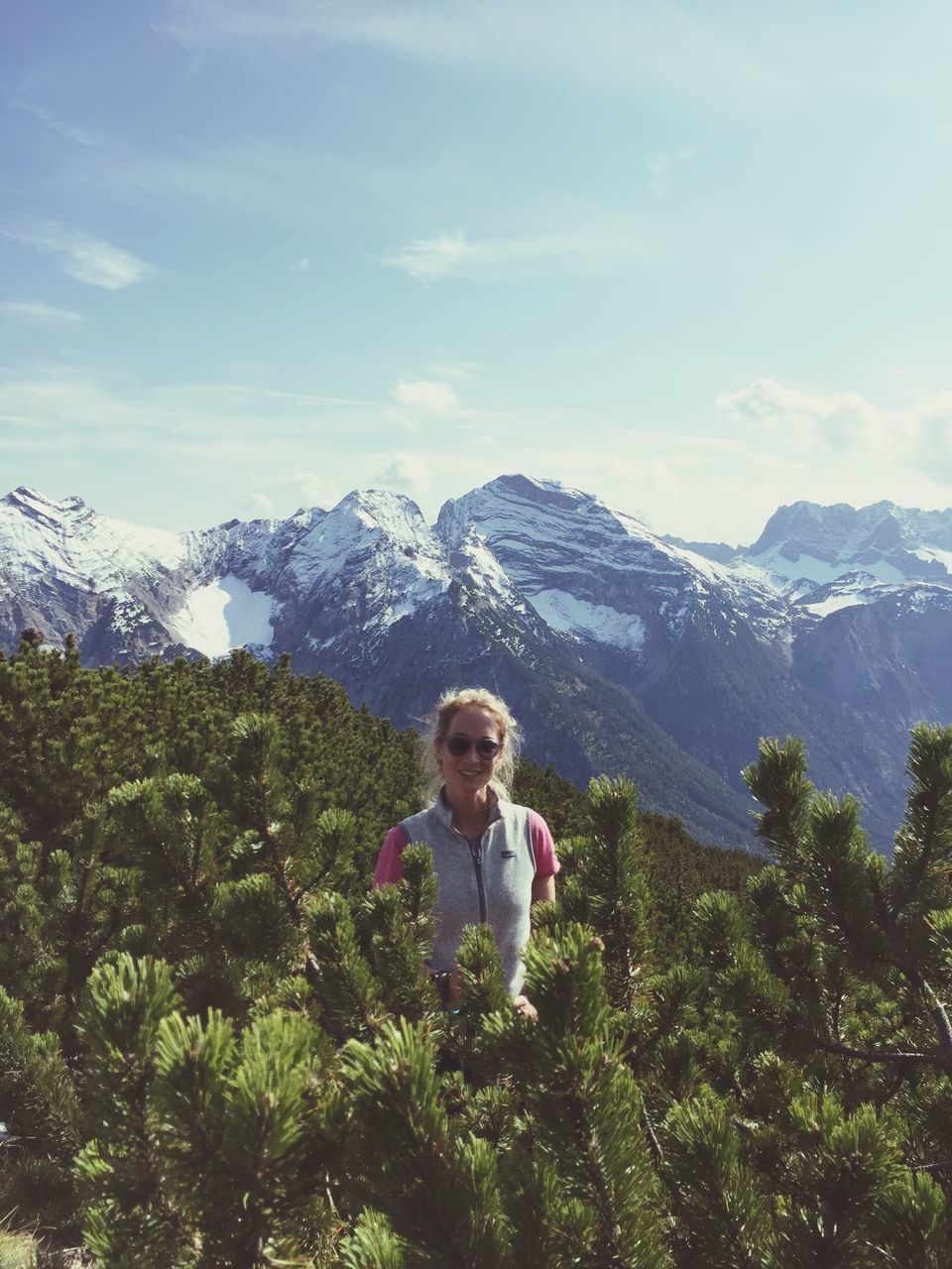 mountain, mountain range, nature, looking at camera, one person, day, mature adult, beauty in nature, leisure activity, real people, sky, lifestyles, casual clothing, mature women, vacations, portrait, scenics, outdoors, happiness, hiking, adventure, standing, smiling, snow, young adult, young women, people