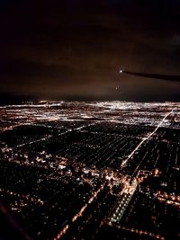 Aerial view of illuminated cityscape against sky at night