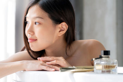 Young woman relaxing in bathtub at home